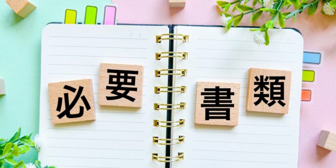 カラフルな背景のノートに「必要書類」と書かれた木製ブロック