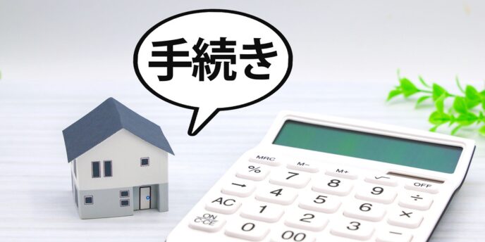「手続き」の文字と住宅模型・電卓が並ぶ画像