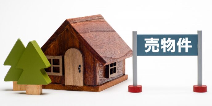 売物件の看板と木製の家の模型