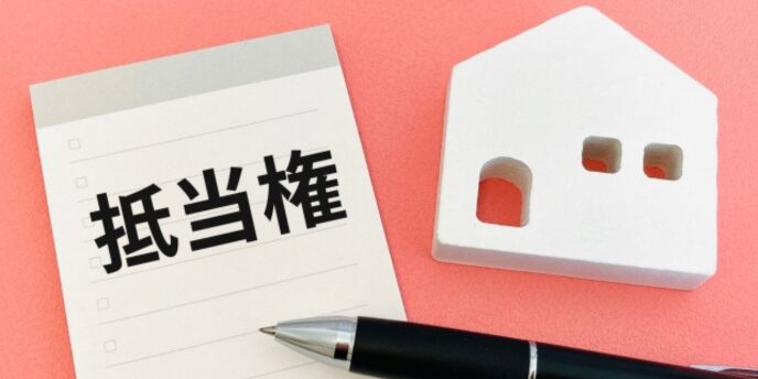 抵当権のメモと住宅の模型、不動産担保やローンに関するイメージ