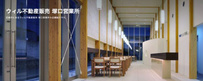 ウィル不動産販売 塚口営業所の店舗内観。木目の柱と大きな窓が特徴で、スタイリッシュで開放感のある接客スペースが広がっている
