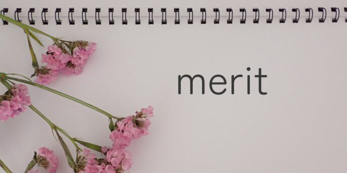 「merit」と書かれたノートとピンクの花が添えられた画像