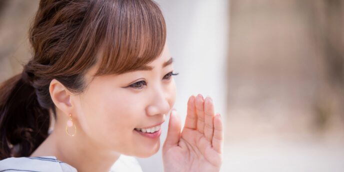 笑顔でこっそり話す女性