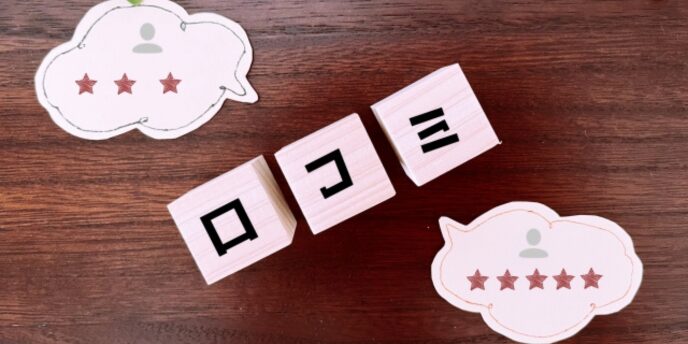 木製のブロックに「口コミ」と書かれ、吹き出しで星評価が示されている画像