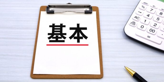 基本と書かれた紙がクリップボードに挟まれ、隣に電卓とペンが置かれている