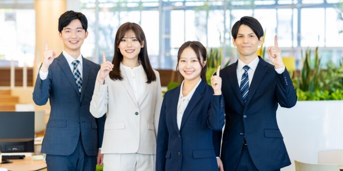スーツ姿で指を立てる社員たち