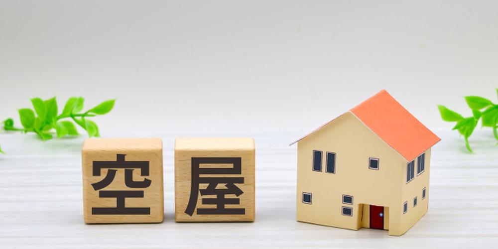 『空き家』と書かれた木製ブロックと住宅模型による空き家問題のイメージ