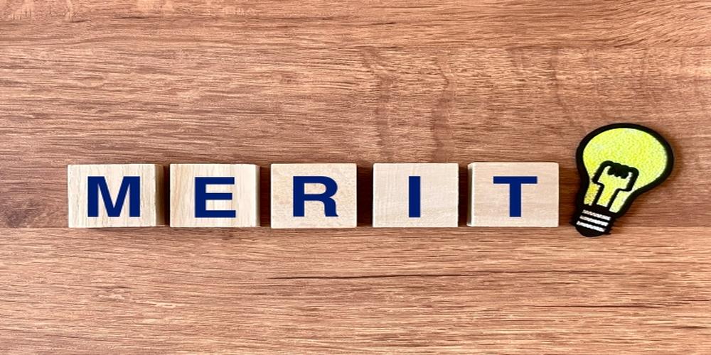 MERITの文字と電球のアイコンが木目の背景に並んだイメージ