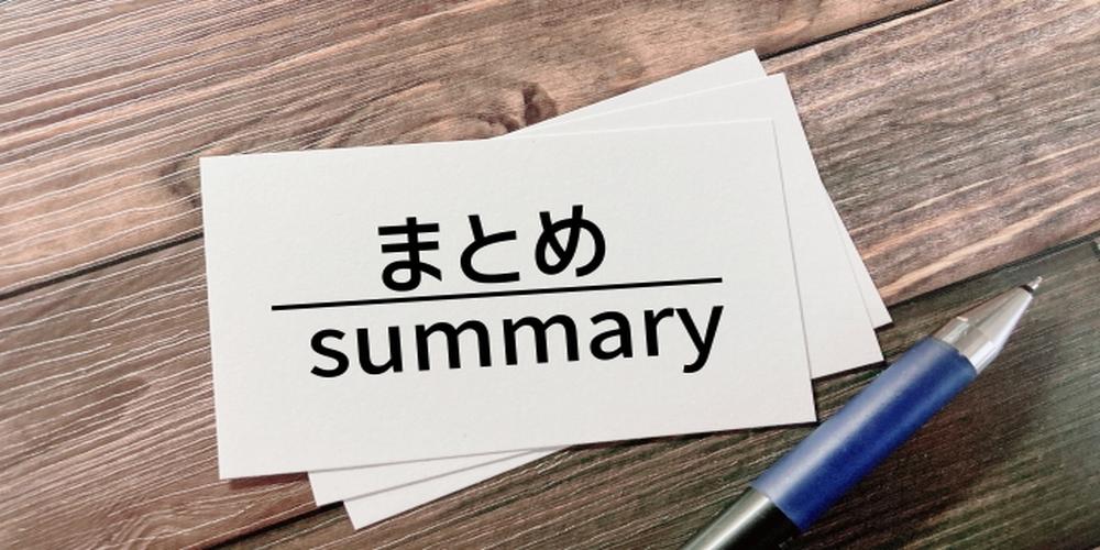 まとめ・summaryと書かれたカードとペンが並ぶ木目背景の画像