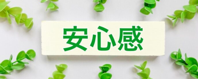 「安心感」という文字が書かれた白いプレートの周りに、放射状に配置された緑の葉が囲む画像。