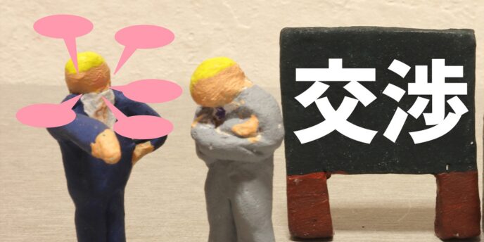 「交渉」と書かれた黒板の前で会話する粘土人形の画像