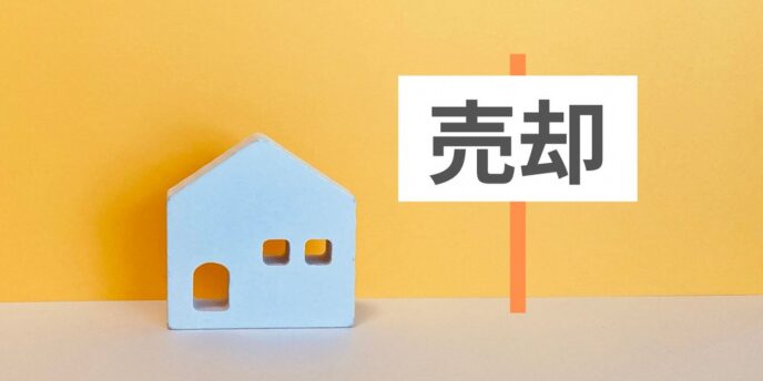 「売却」と書かれた吹き出しと青い家の模型
