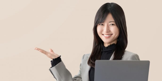 パソコンを持ち案内する女性