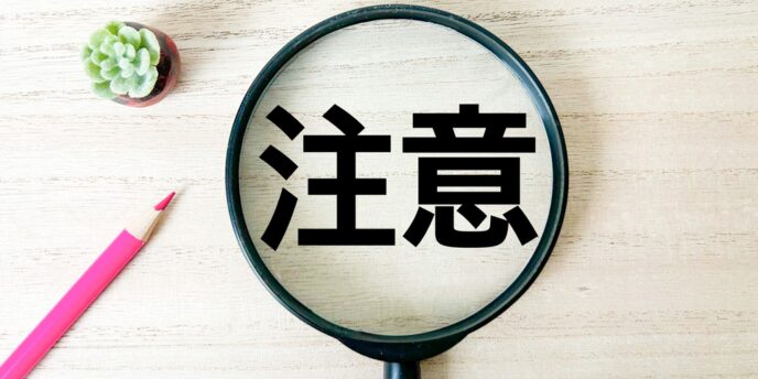 「注意」の文字を虫眼鏡で拡大している画像