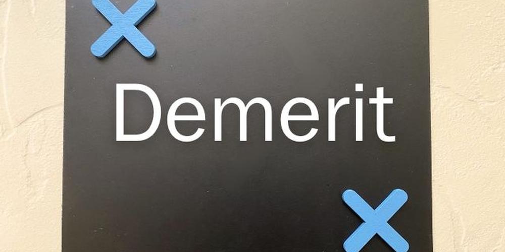 黒板風の背景に『Demerit』