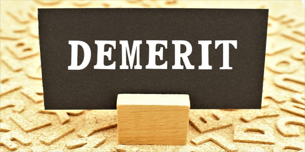 DEMERITと書かれた黒いカード と木製スタンド