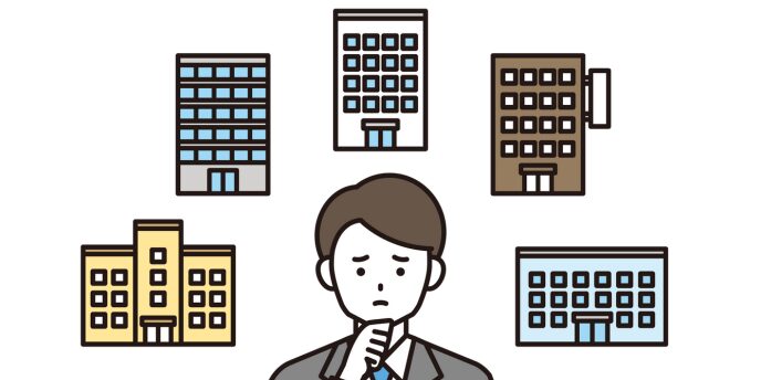 複数の建物を前に悩んでいる男性のイラスト