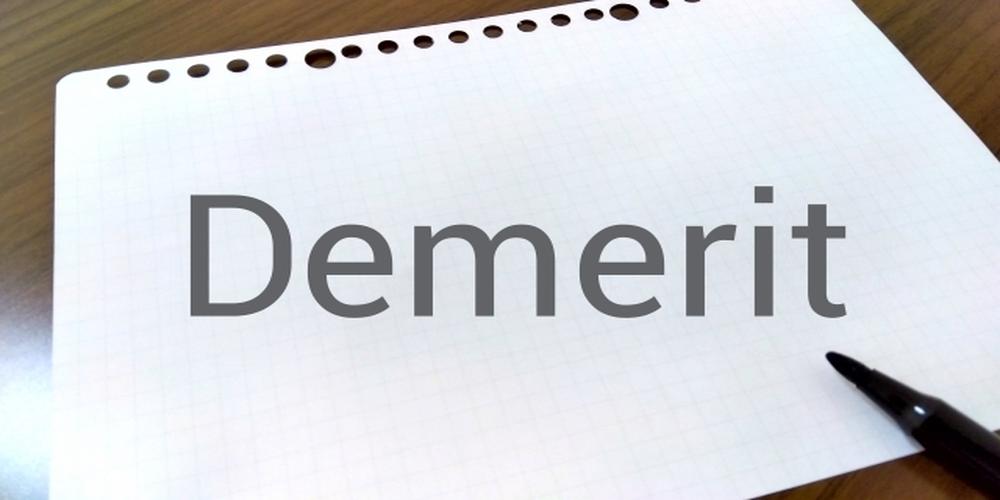 Demeritと書かれたノートとペンが置かれたシンプルなデスクのイメージ