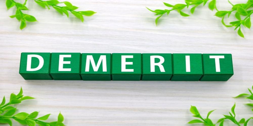 DEMERITと書かれた緑のブロックが葉に囲まれて並ぶ画像