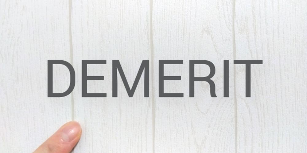木目の壁に「DEMERIT」の文字と指差し